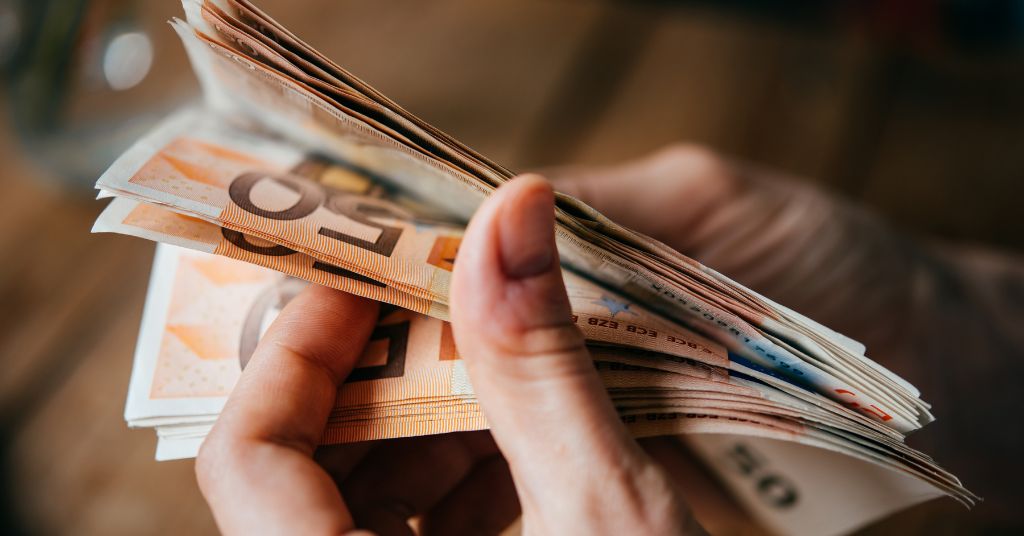 Bonus 150 euro sul Reddito di cittadinanza del 15 giugno 2023: in foto, delle banconote da 50 euro tra due mani.