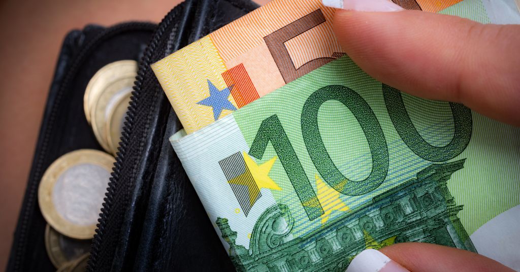Il Bonus 150 euro sarà pagato ad agosto 2023 a chi ne aveva diritto e deve ancora riceverlo. Nella foto banconote da 50 e 100 euro con monete in euro visibili in secondo piano.